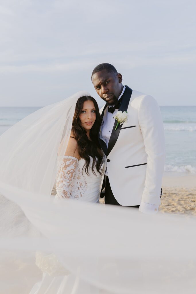 Beautiful image of Abby and Davon, wedding couple at dreams macao beach in the Dominican Republic with draping veil.